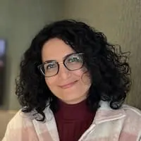 A woman wearing glasses and a plaid jacket.